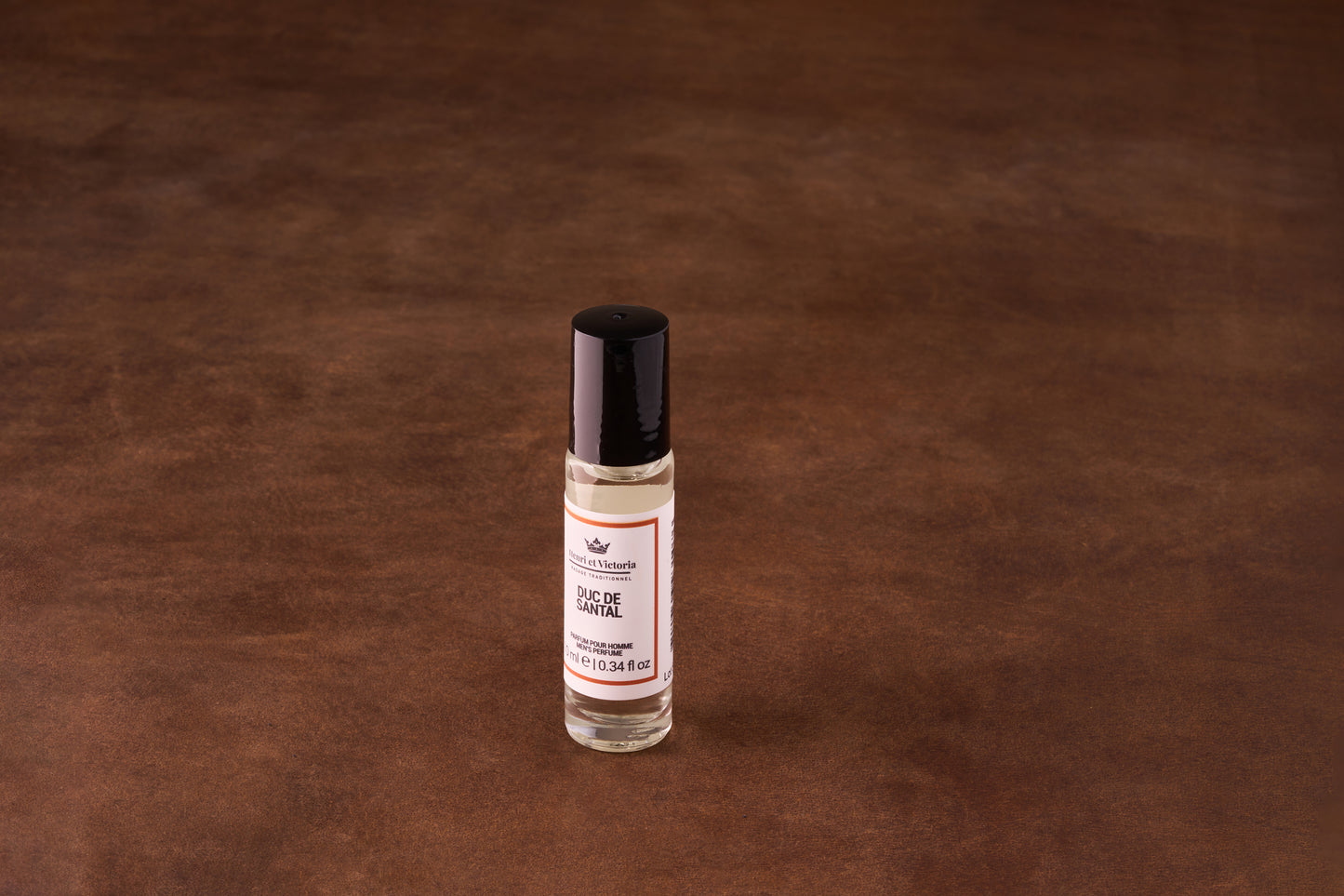 Henri et Victoria Duc de Santal Perfume in a 10 ml roll-on bottle, showcasing a blend of muskiness and sandalwood, ideal for travel.
