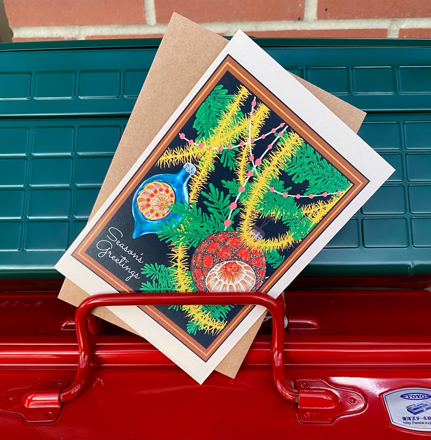 Colorful greeting card with a peacock design on a red mailbox.