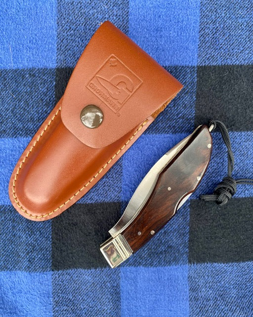 Knife with leather sheath on a blue plaid background