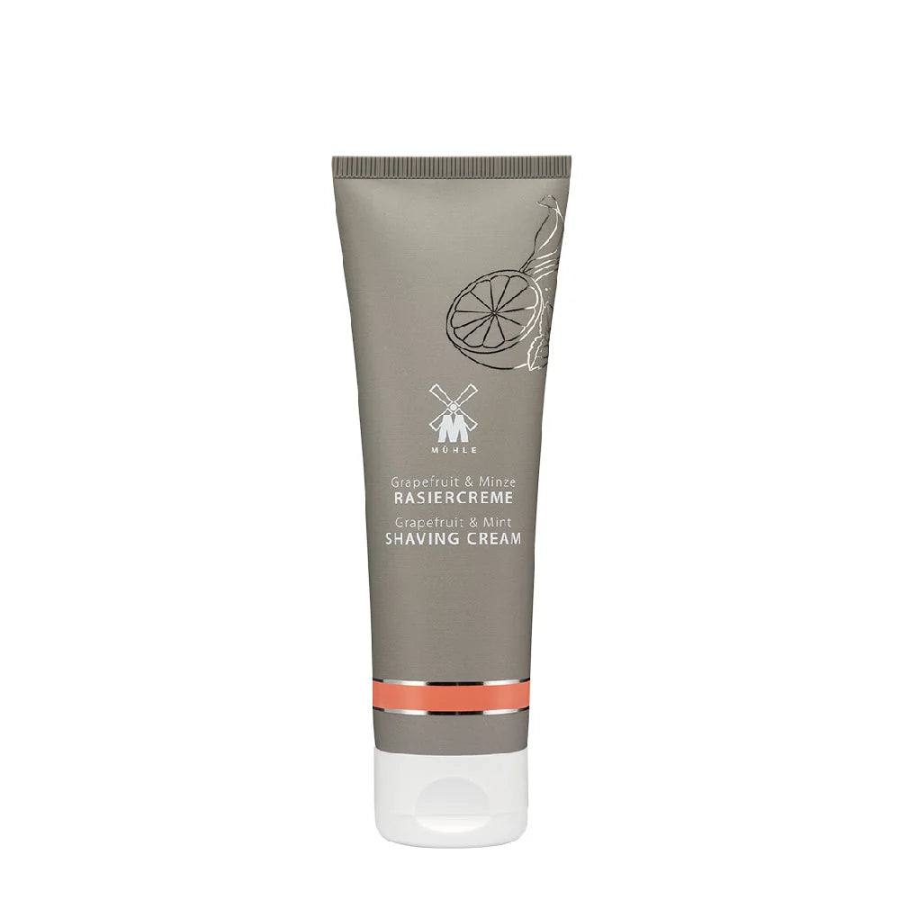 A tube of Mühle Grapefruit & Mint Shaving Cream featuring a gray body, white cap, and minimalist citrus and mint design on the front, formulated with natural essential oils for a nourishing shave.