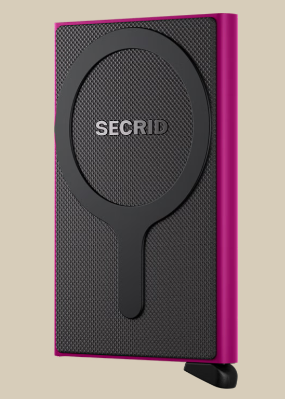 A slim, rectangular Secrid Wallets Cardprotector for MagSafe with a textured black front, circular MagSafe-compatible design, RFID blocking, and vibrant pink edges stands on a small black tab against a beige background.