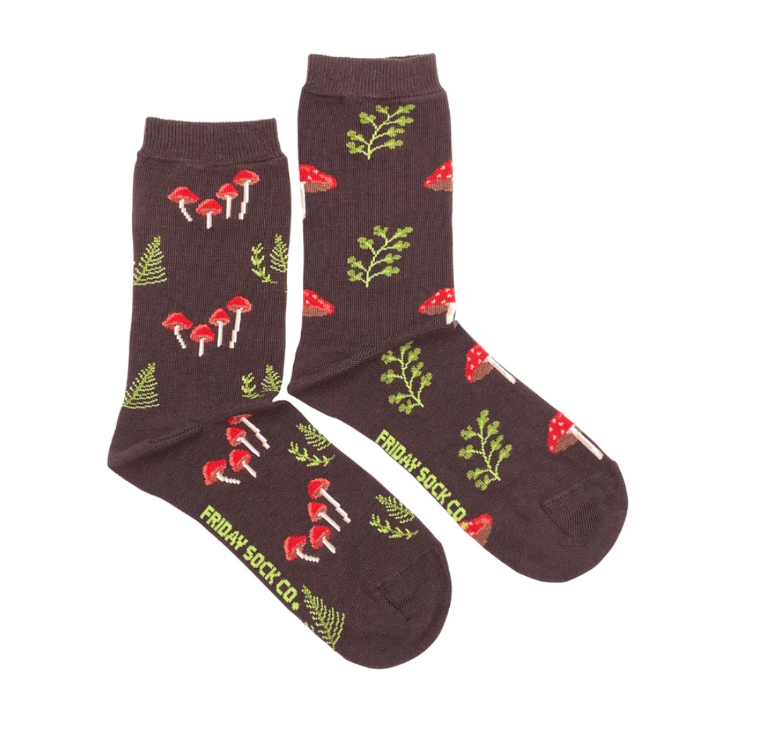 Friday Sock Co. Mushroom forest Womens crew socks in brown with a repeating pattern of red mushrooms and green ferns, featuring the brand name printed on the foot.