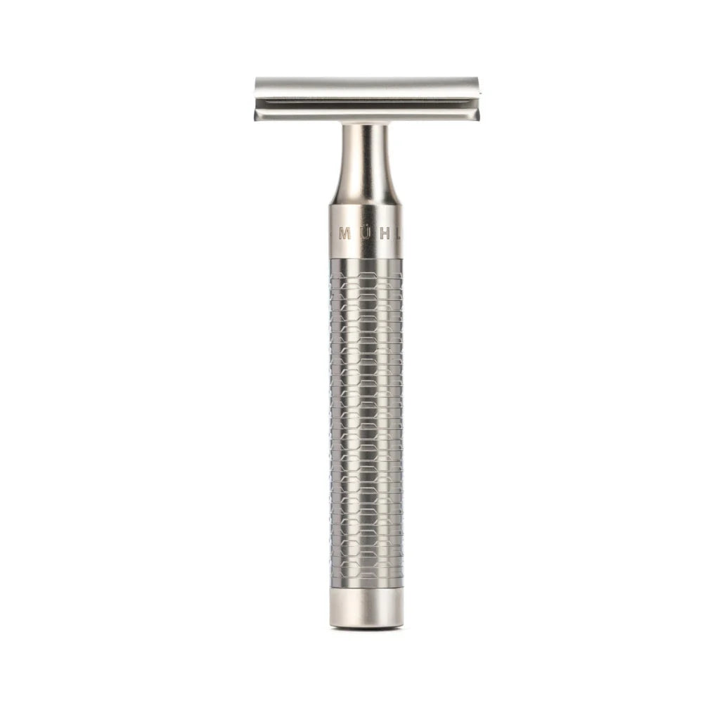 The Mühle Rocca Safety Razor, featuring a textured handle and crafted from stainless steel, stands upright on a plain white background—perfectly embodying modern shave culture.