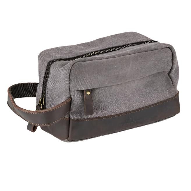 Kent of Inglewood Dopp Kit, a grey canvas bag with dark brown leather accents, ideal for travel or home organization, featuring a top zipper and side handle.