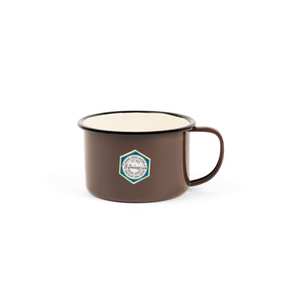 Crow Canyon Camp Wandawega Enamel Soup Mug, featuring a brown enamel exterior, cream interior, and hexagonal logo, embodies rustic charm and timeless simplicity.