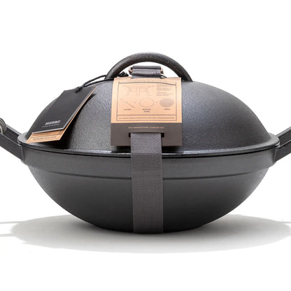 Barebones All-in-One Cast Iron Grill, a portable two-piece system with a domed lid, handles, and transport strap, ideal for versatile outdoor cooking.