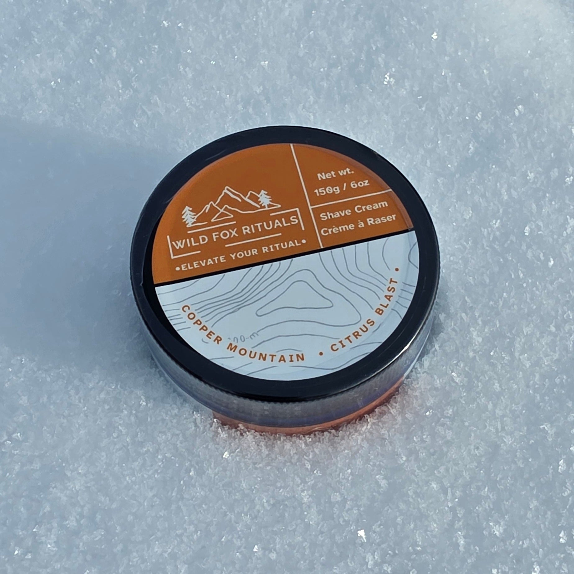 Shave cream container with 'Wild Fox Rituals' branding on a textured gray background