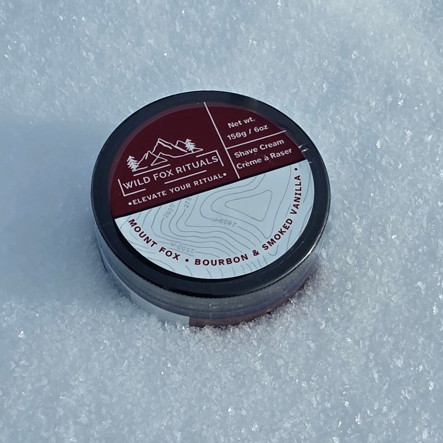 Shave cream container with label on a snowy background