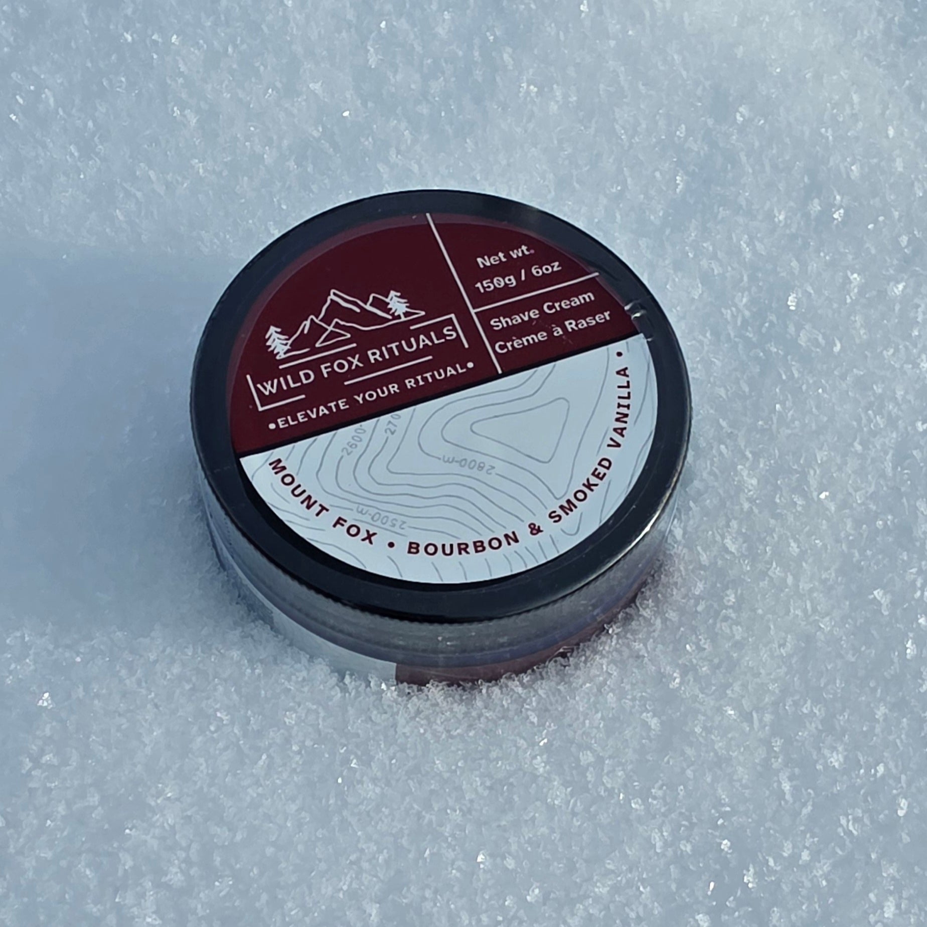Shave cream container with label on a snowy background