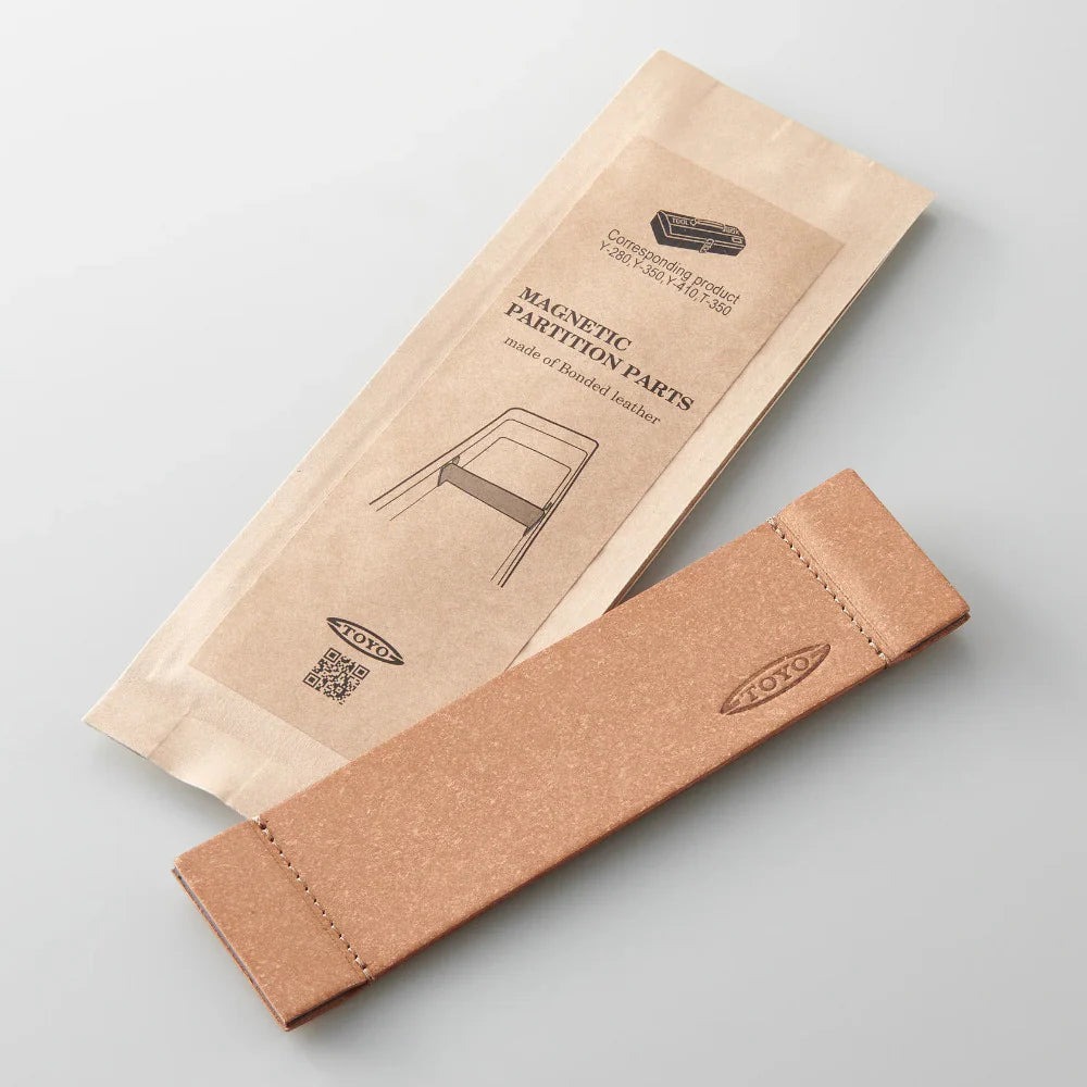 A Toyo 350 series Bonded Leather Partition in brown sits by its matching paper packaging labeled "Magnetic Partition Parts" and "TOYO"—ideal for organizing your Toyo Steel rugged or seamless toolboxes.