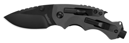 The Kershaw Shuffle DIY is a black folding tactical knife with a partially serrated blade, contoured handle, and built-in multi-tool features such as a screwdriver and glass breaker.