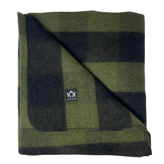 Arcturus Backwoods Wool Blanket - Buffalo Plaid, folded with a green-and-black check pattern, features a woven label. Ideal for outdoor use, blending durability and washability.