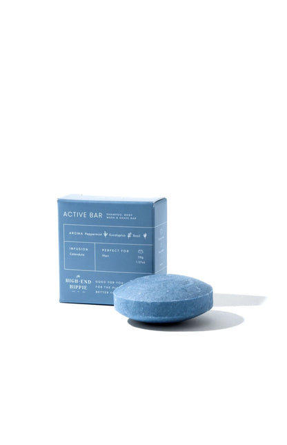 The High End Hippie Active Shampoo Bar, a blue 3-in-1 grooming solution for men, with peppermint, eucalyptus, and basil scent, beside matching eco-friendly packaging.