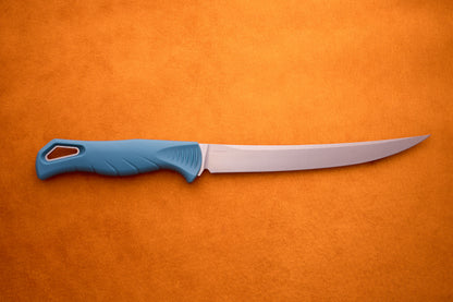 A Benchmade Fishcrafter with a long, thin blade and blue handle lies on an orange surface, making it ideal for precise filleting tasks.