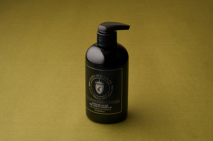 A black pump bottle of Crown Shaving Co. Preshave 225ml rests on a green surface, showcasing a crown logo along with gold and white text on the front. This pre-shave beard lubricant features a water-based formula designed to deliver a smooth and comfortable shaving experience.