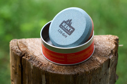 Two cylindrical containers, one blue and one red, on a wooden post with a blurred green background.