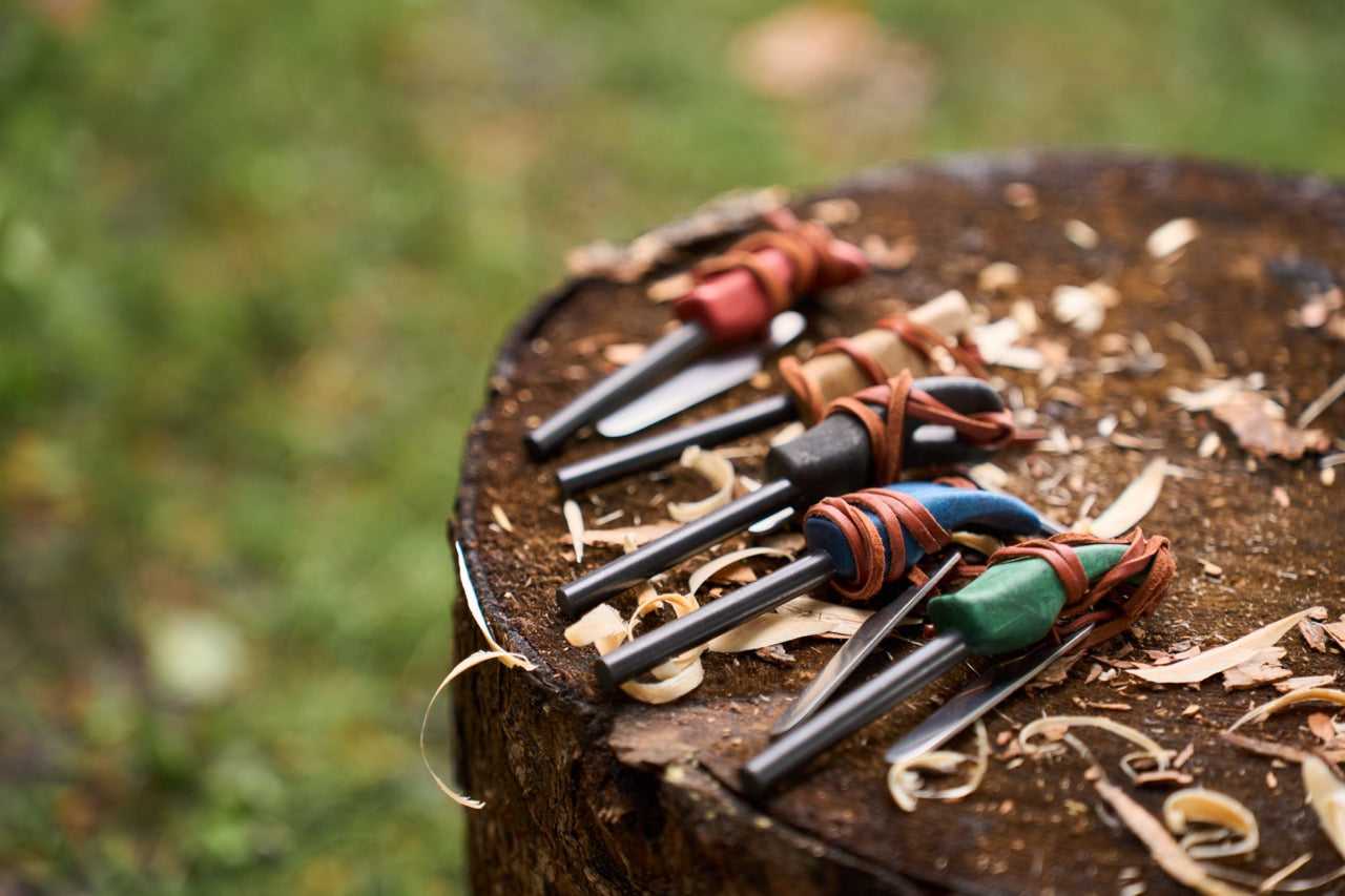Set of leather-wrapped tools on a wooden surface with a blurred natural background