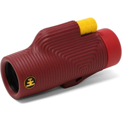 The NOCS Provisions Zoom Tube 8x32 Monocular is a compact, water-resistant red monocular featuring textured, curved ridges, a yellow focus knob, and a small circular logo with three horizontal lines inside a black circle near the lens—blending sleek style and practical functionality in one optical tool.
