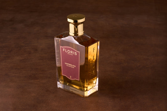 Floris Leather Oud Eau de Parfum in a rectangular glass bottle with amber liquid and a gold lid, embodying sophisticated and timeless masculine elegance.