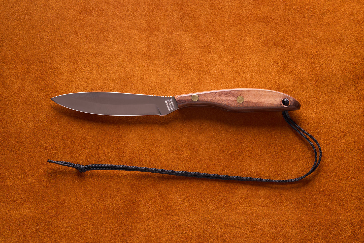 Grohmann D.H. Russell Belt Knife #2 Trout & Bird features a stainless blade, rosewood handle with brass rivets, and black paracord lanyard, ideal for precision tasks.