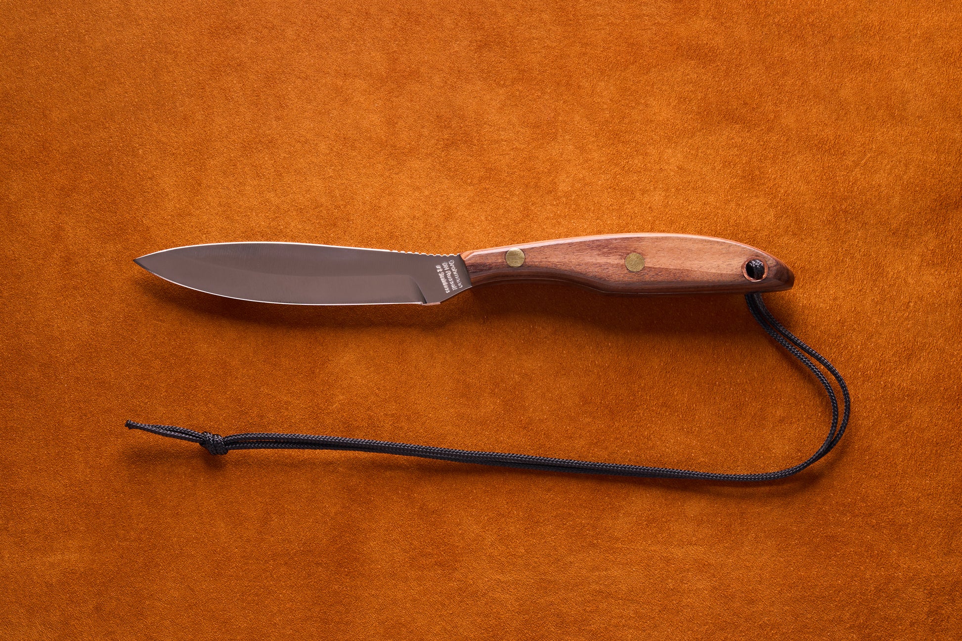 Grohmann D.H. Russell Belt Knife #2 Trout & Bird features a stainless blade, rosewood handle with brass rivets, and black paracord lanyard, ideal for precision tasks.