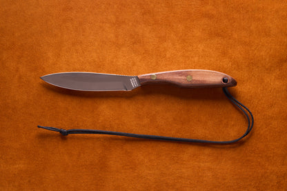 Grohmann D.H. Russell Belt Knife #2 Trout & Bird features a stainless blade, rosewood handle with brass rivets, and black paracord lanyard, ideal for precision tasks.