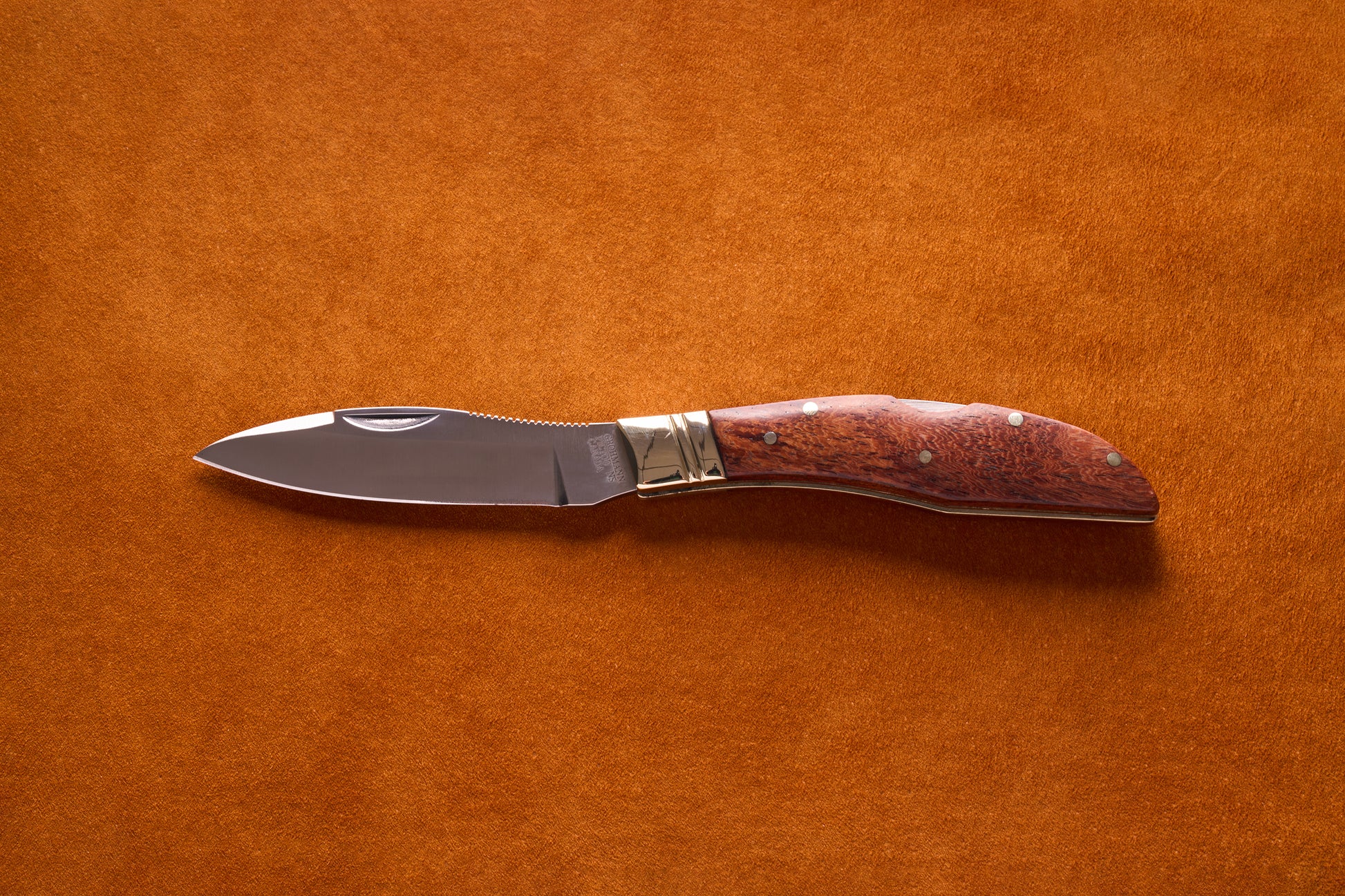 Grohmann Mini Russell Lockblade with Rosewood Handle, 4, featuring a stainless steel drop-point blade and polished hardwood handle, displayed on a suede surface.