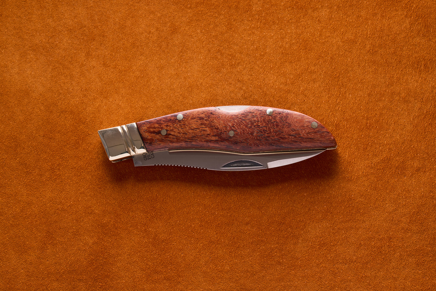 Grohmann Mini Russell Lockblade, 4, with a rosewood handle and stainless steel blade, resting on a suede surface.