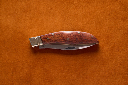 Grohmann Mini Russell Lockblade, 4, with a rosewood handle and stainless steel blade, resting on a suede surface.