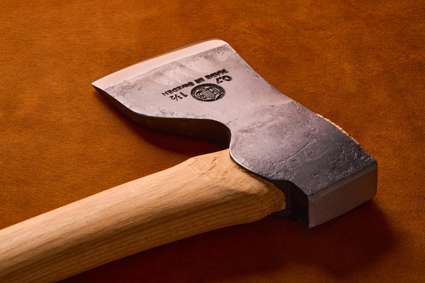 Wooden-handled axe with a metallic head on a brown background