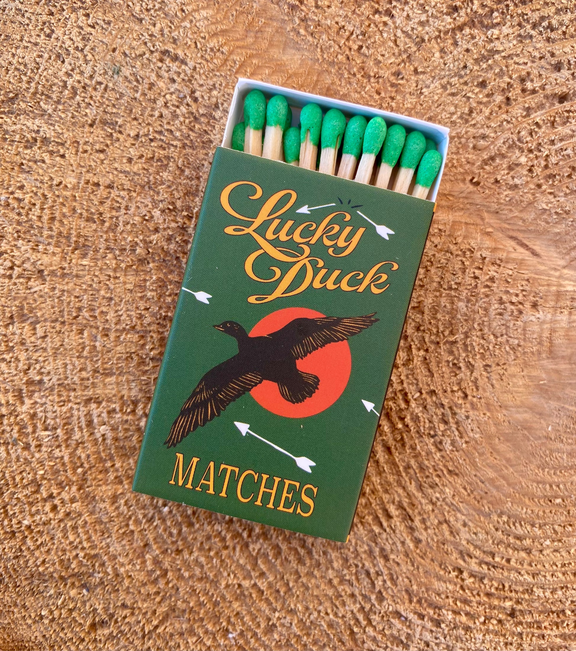 Matchbox labeled 'Lucky Duck Matches' on a wooden surface