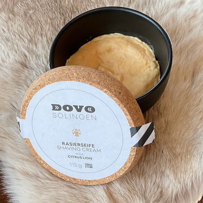 Dovo Citrus Lion Shaving Soap in a black bowl with cork-top lid, featuring notes of mandarin, cedar, and sandalwood for a classic shaving experience.