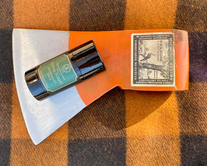 Taylor of Old Bond Street Royal Forest Deodorant Stick displayed on an axe head, highlighting its blend of classic British craftsmanship and luxurious fragrance.