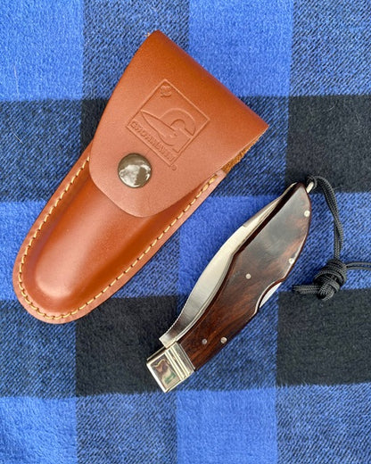 Knife with leather sheath on a blue plaid background