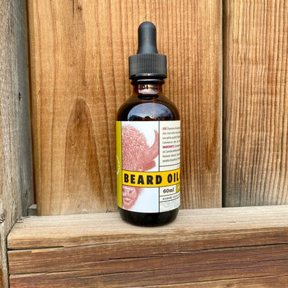 Kent of Inglewood Forest Beard Oil in a 60 ml amber-glass dropper bottle, designed to enhance and moisturize beards, displayed on a wooden shelf.