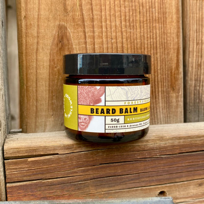 Kent of Inglewood Forest Beard Balm in an amber-glass jar on a wooden shelf, providing moisture and light hold with a refreshing forest scent.