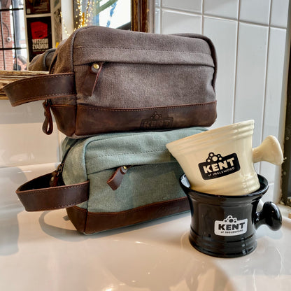 Dopp Kit & Shaving Mug Bundle featuring Kent of Inglewood's canvas-and-leather bags and ceramic shaving scuttles, stylishly arranged on a countertop.