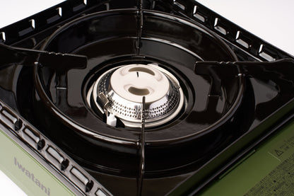A close-up view of the Iwatani Cassette Konro "Tough Maru" Portable Stove, a butane-powered camping burner featuring black metal grates and a silver burner head on a green base, photographed against a white background.