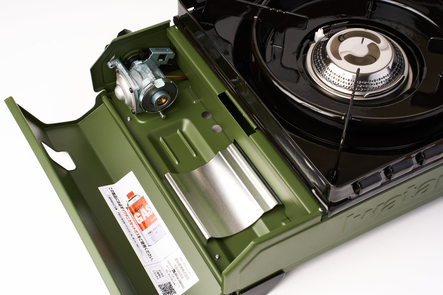 A close-up of an Iwatani Cassette Konro "Tough Maru" Portable Stove in green with its lid open, displaying the burner, gas cartridge compartment, and a label featuring usage instructions.