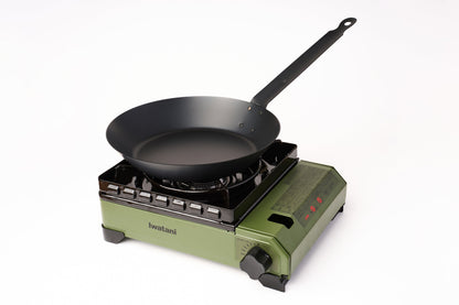 A black frying pan sits on an Iwatani Cassette Konro "Tough Maru" Portable Stove with control knobs and the brand name “Iwatani” visible on the base, set against a plain white background.