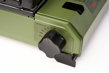 Close-up of the Iwatani Cassette Konro "Tough Maru" Portable Stove, featuring a green butane-powered design, a black control knob with Japanese labeling, and a partial view of the stove’s burner area.