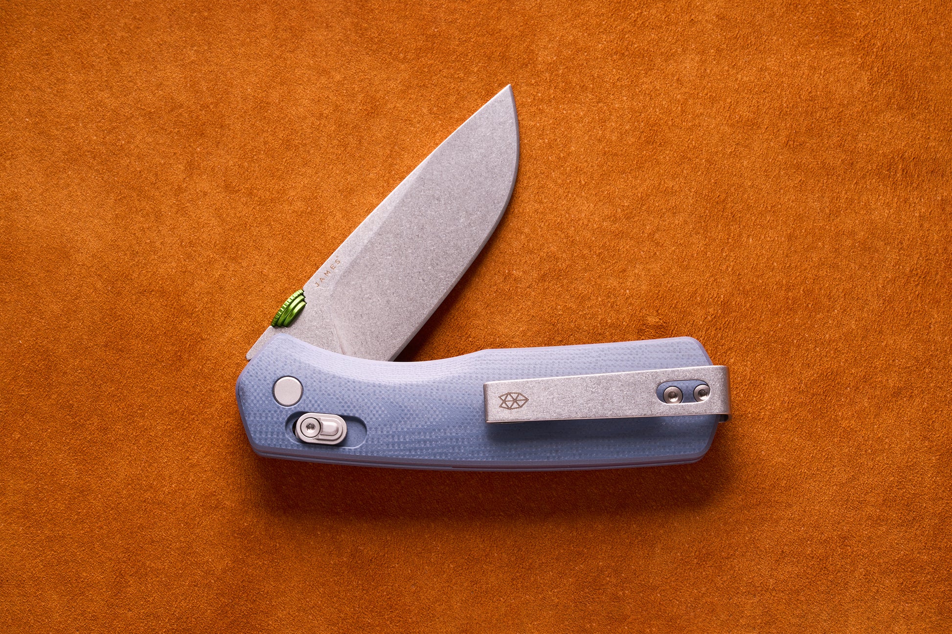 James Carter folding pocket knife with a stone-washed blade, translucent blue handle, green thumb-stud, and slide-lock mechanism, ideal for everyday carry.