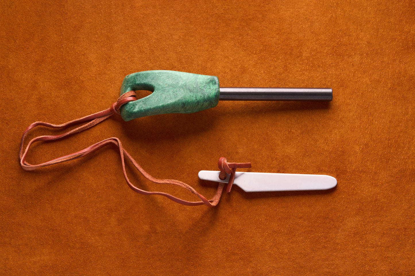 Kupilka Firesteel, a compact fire-starting kit with a ferro rod in a green handle and scraper, ideal for backpackers and campers.