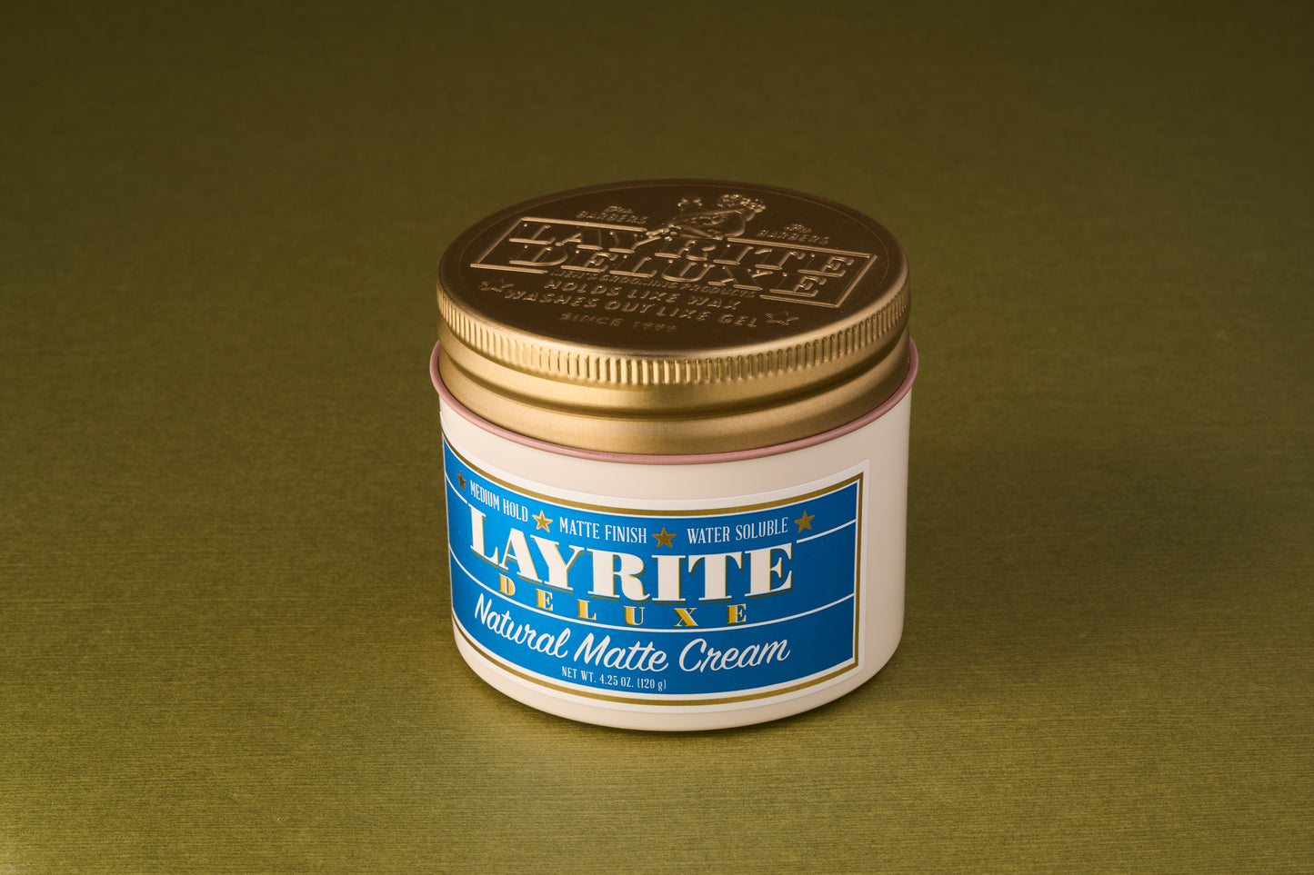 Layrite Natural Matte Cream jar with gold lid and blue label, offers medium hold and matte finish for natural hairstyles. Ideal for casual looks, water-soluble.