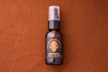 Mammoth Beard Co. Beard Oil - Sex & Cigars 30ml bottle with pump, offering a smoky, sweet scent, set against a textured leather backdrop.