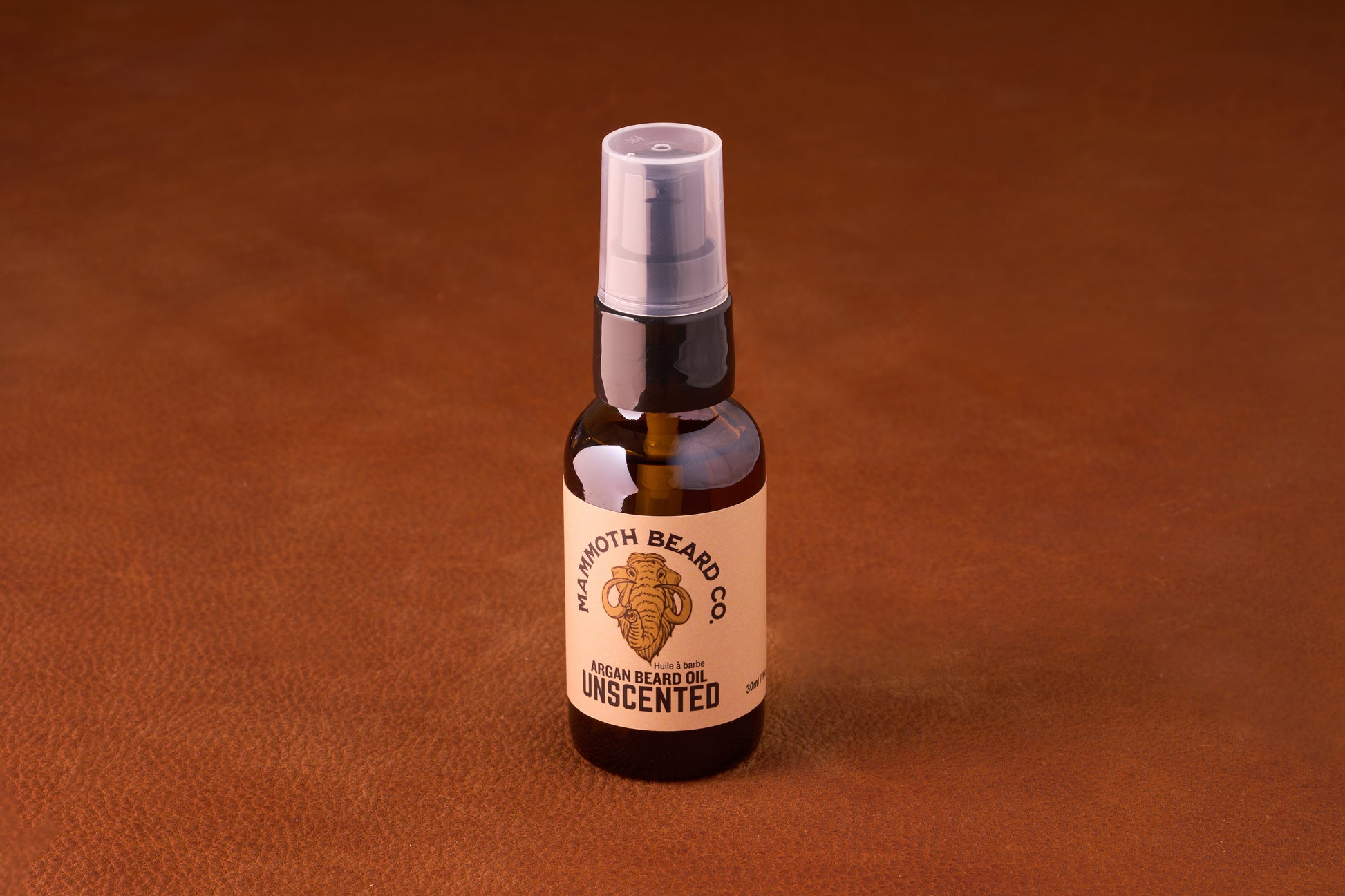 Mammoth Beard Co. Beard Oil - Unscented 30ml in an amber pump bottle on leather surface, offering a regal look for beards with premium ingredients.