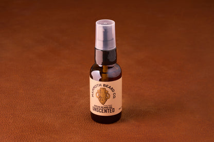 Mammoth Beard Co. Beard Oil - Unscented 30ml in an amber pump bottle on leather surface, offering a regal look for beards with premium ingredients.