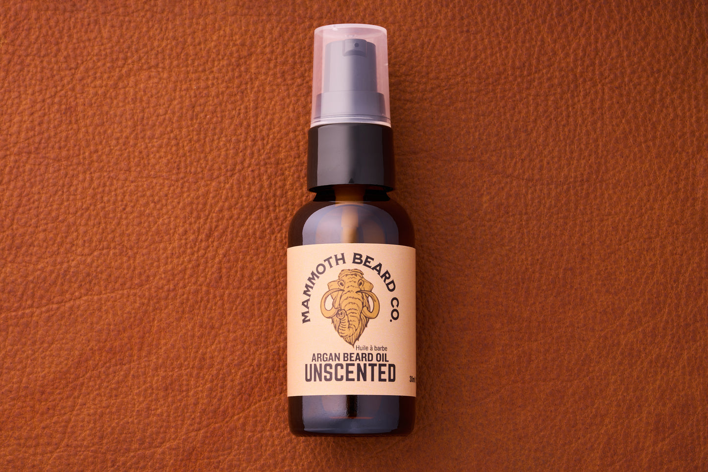 Mammoth Beard Co. Beard Oil - Unscented 30ml bottle with pump, featuring a woolly mammoth logo, set on a leather background.
