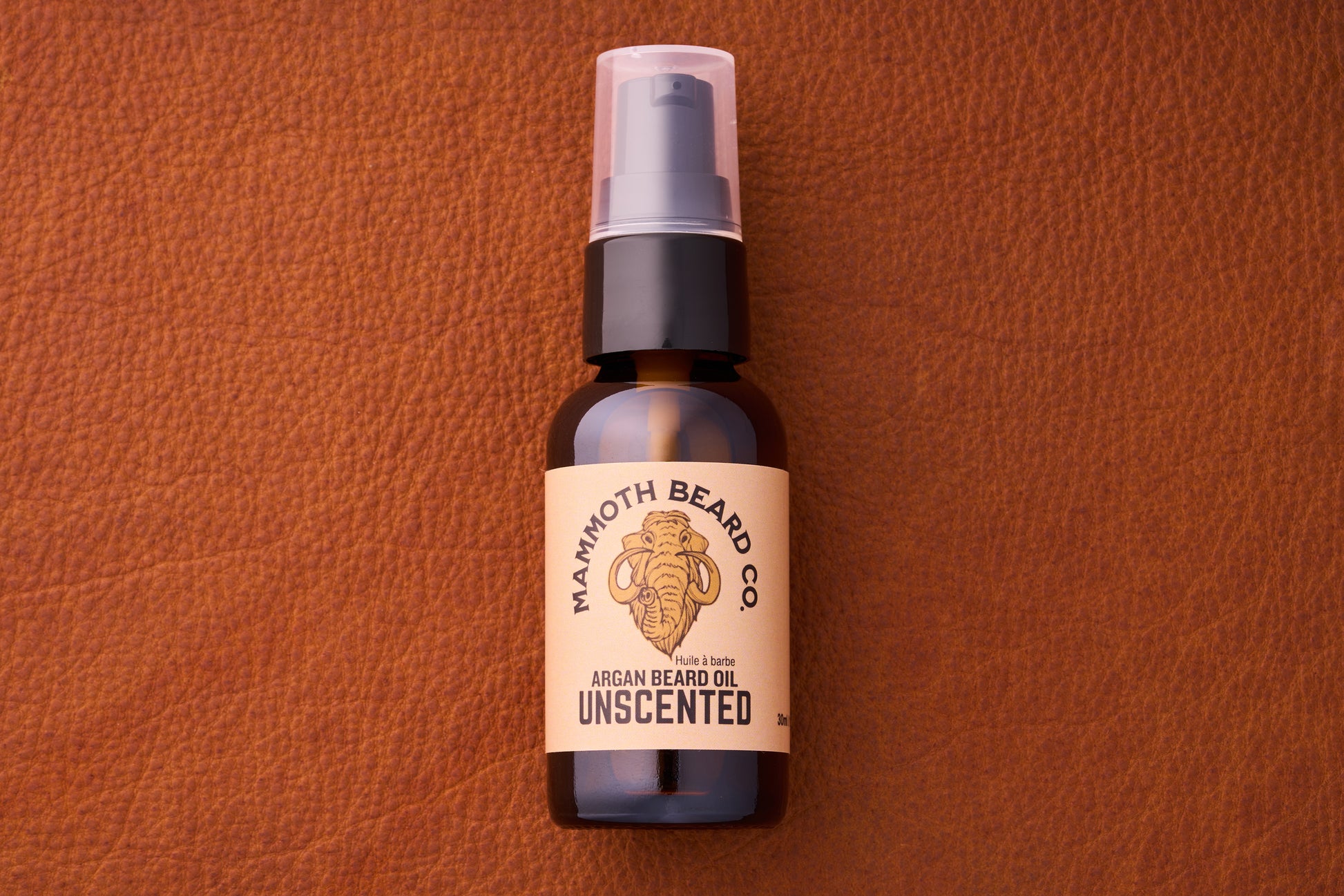 Mammoth Beard Co. Beard Oil - Unscented 30ml bottle with pump, featuring a woolly mammoth logo, set on a leather background.