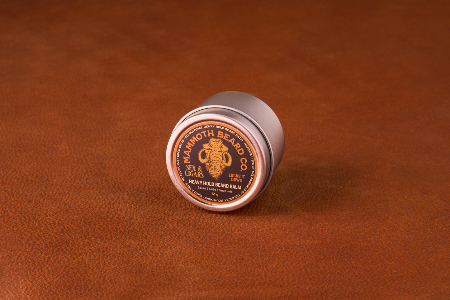 Mammoth Beard Co. Strong Hold Beard Balm Sex & Cigars 60ml on leather surface; crafted with natural oils for styling and moisture, featuring a smoky, sweet scent.